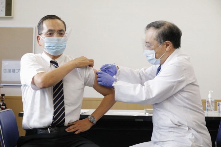 Leyenda: Kazuhiro Araki (izq.), Director del Centro Médico de Tokio, es vacunado por un colega en su propio hospital ubicado en el distrito de Meguro, convirtiéndose en la primera persona en ser vacunada en Japón. (Foto: Kyodo News)